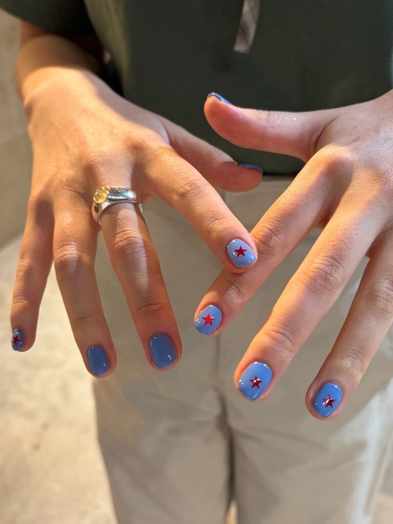 Short cornflower blue nails with small red star accents