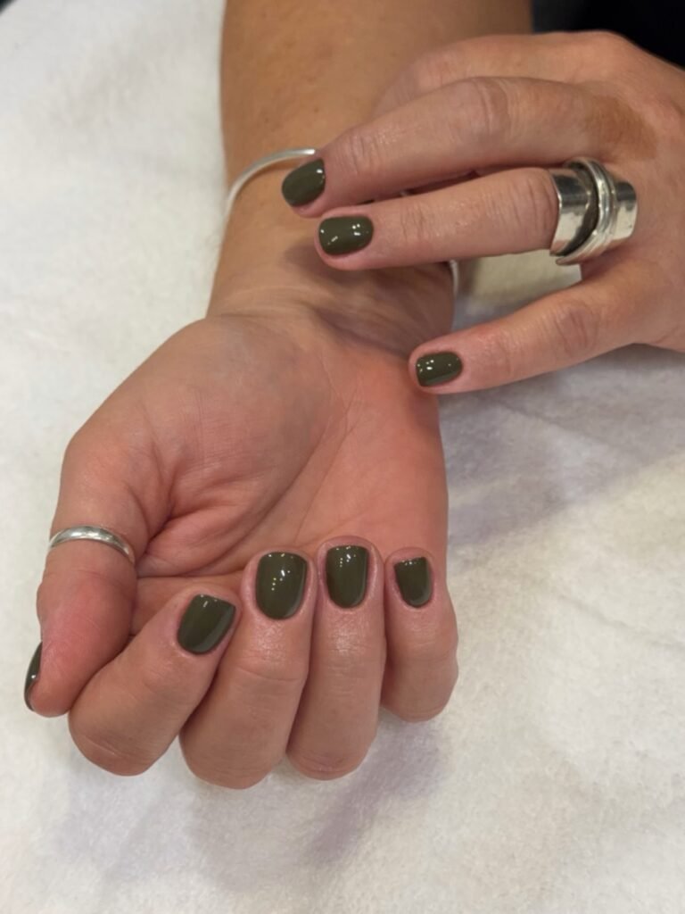 short olive green nails on rounded shape, glossy dark green November manicure
